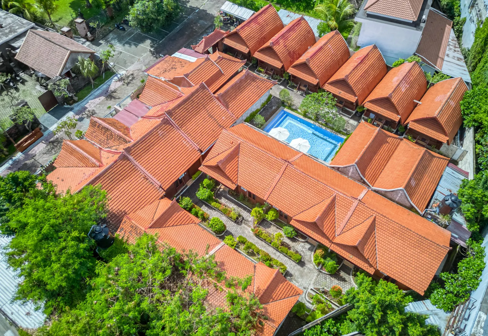 Aerial view of wooden villas surrounding the swimming pool
