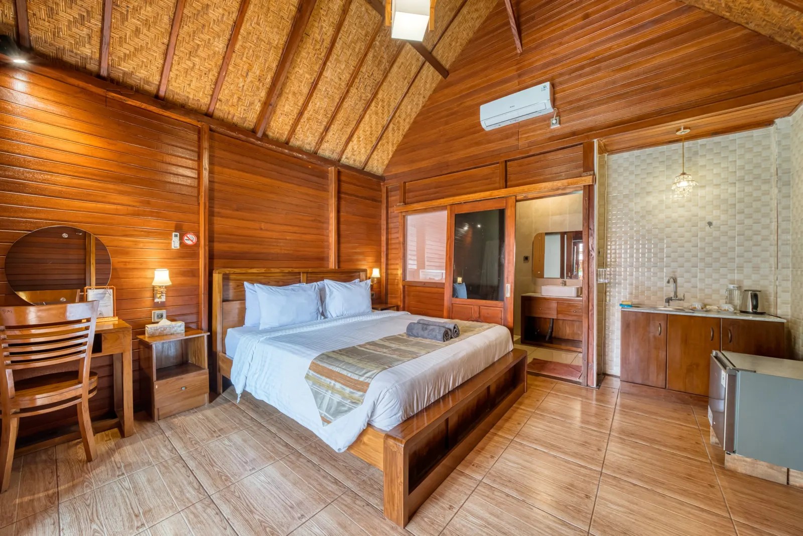 Wooden bedroom with a double bed, desk and bathroom entrance