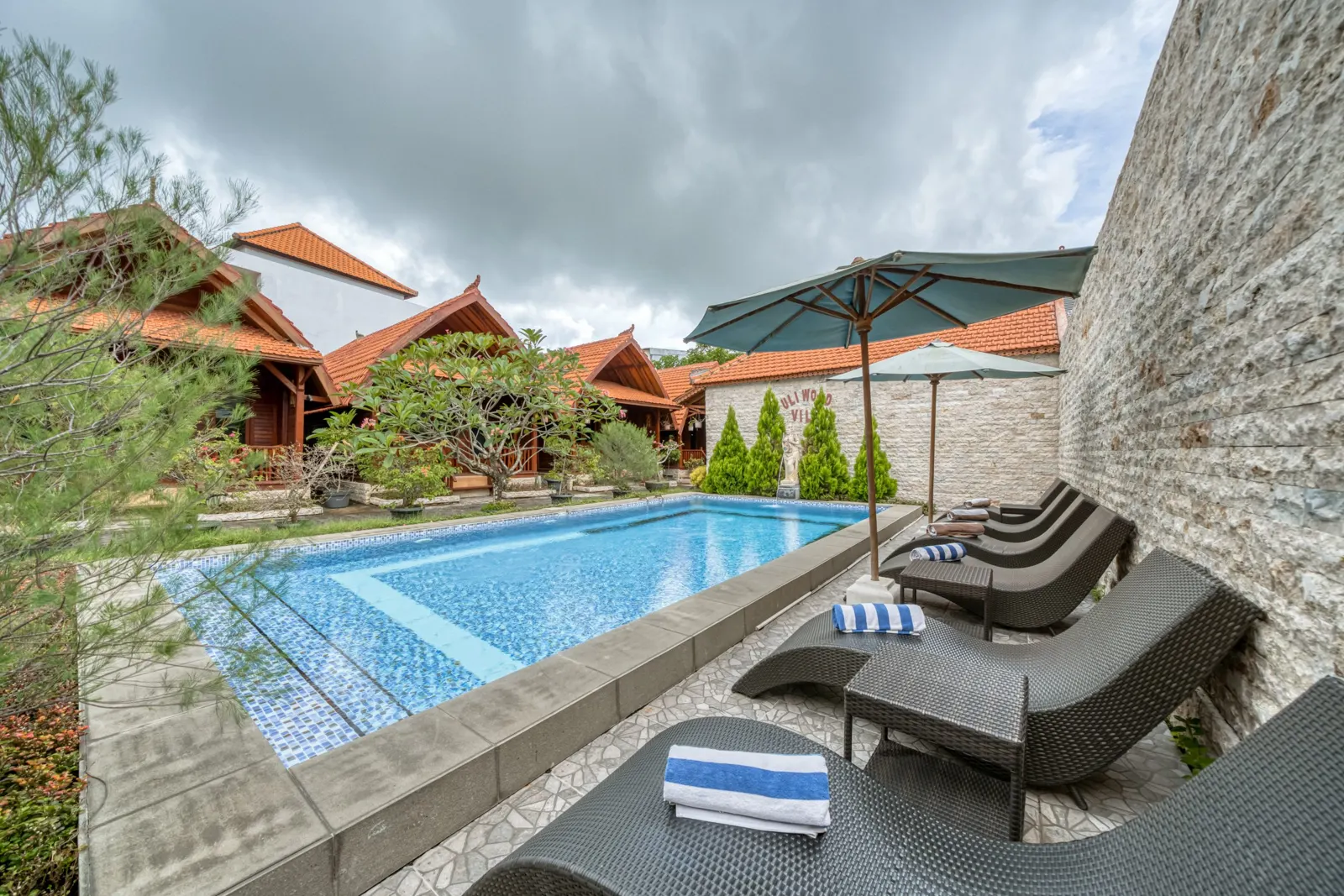 Swimming pool and loungers beside a stone wall