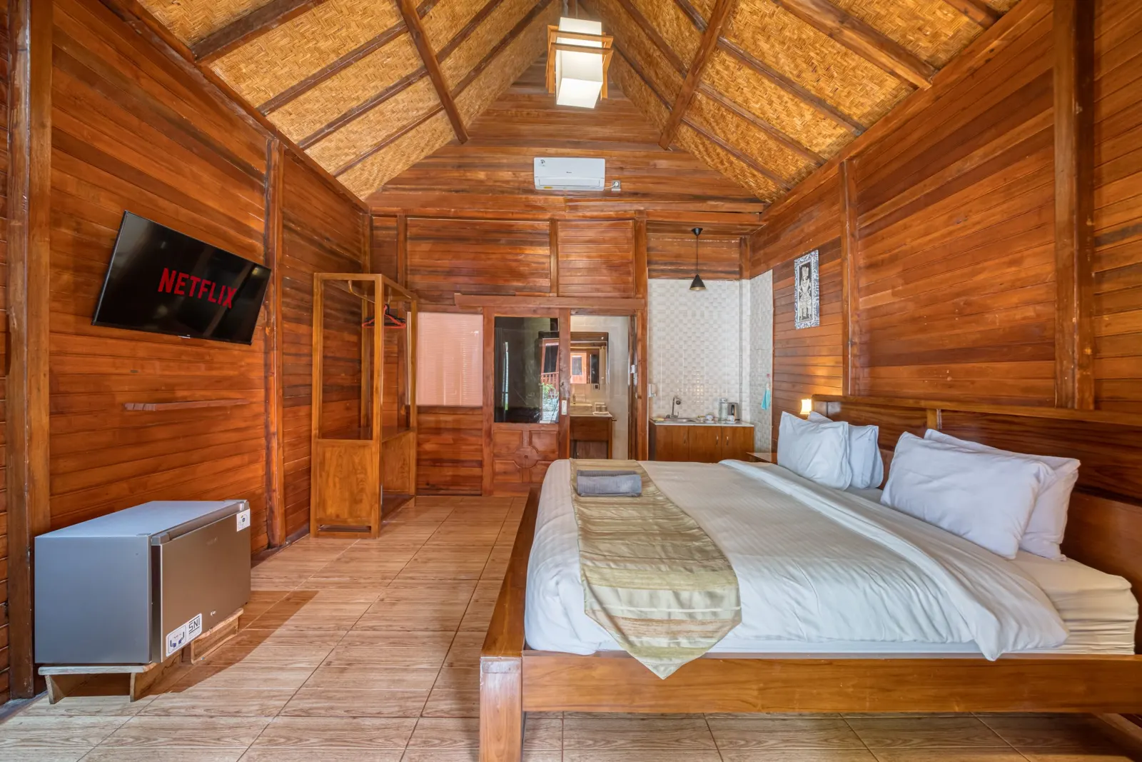 Spacious wooden bedroom with a double bed and seating area