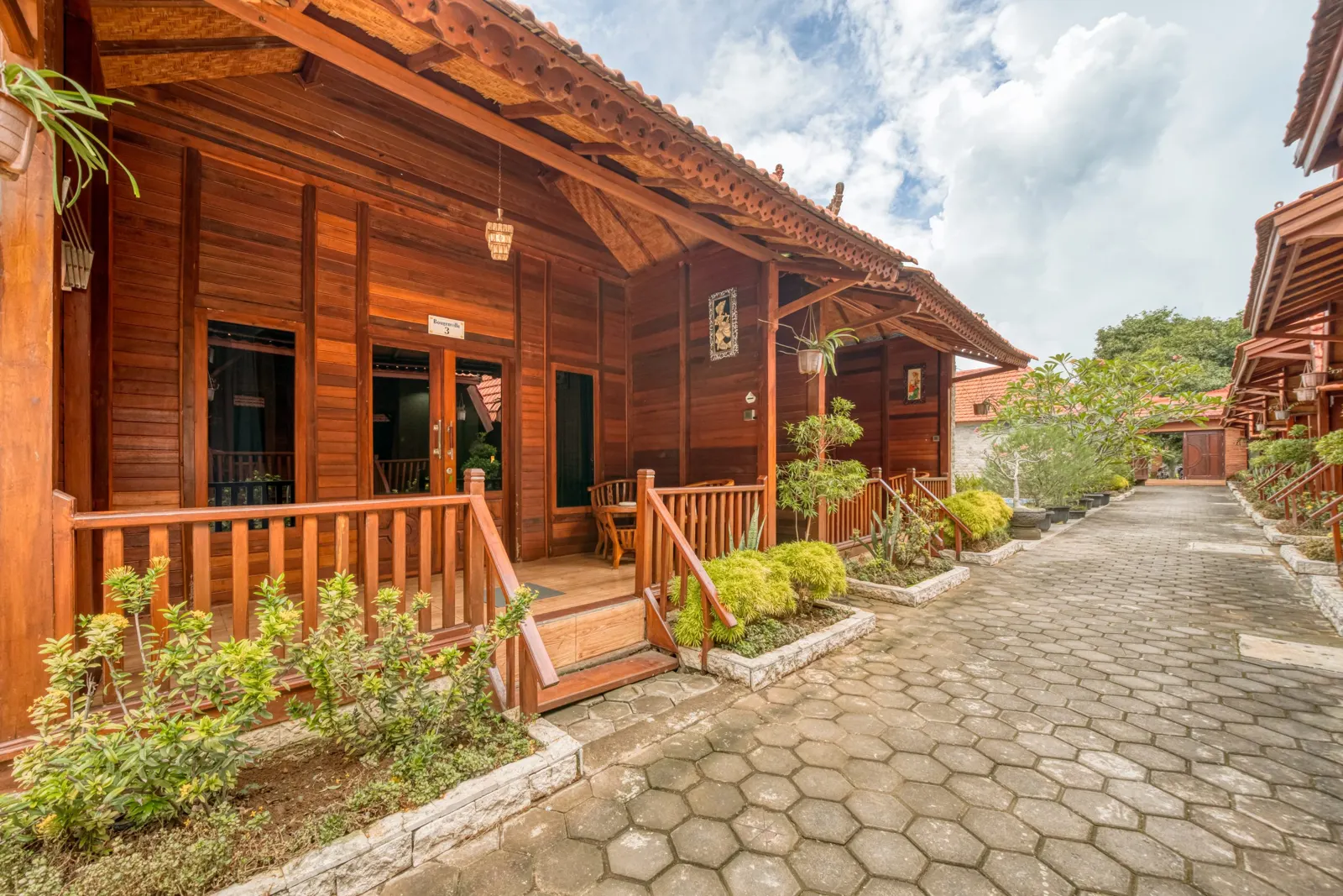 Wooden villa verandas along the paved garden walkway