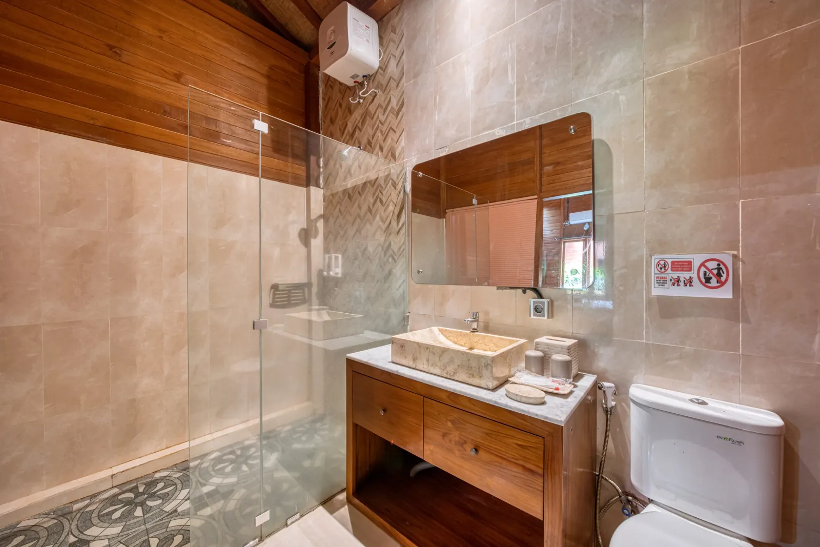 Stone-tiled bathroom with a mirror and wooden washstand