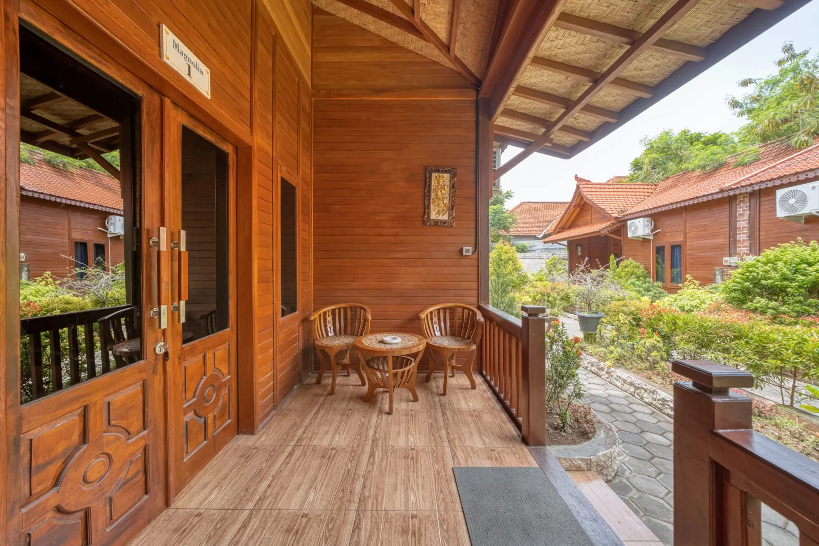 Covered wooden veranda with a table overlooking the garden