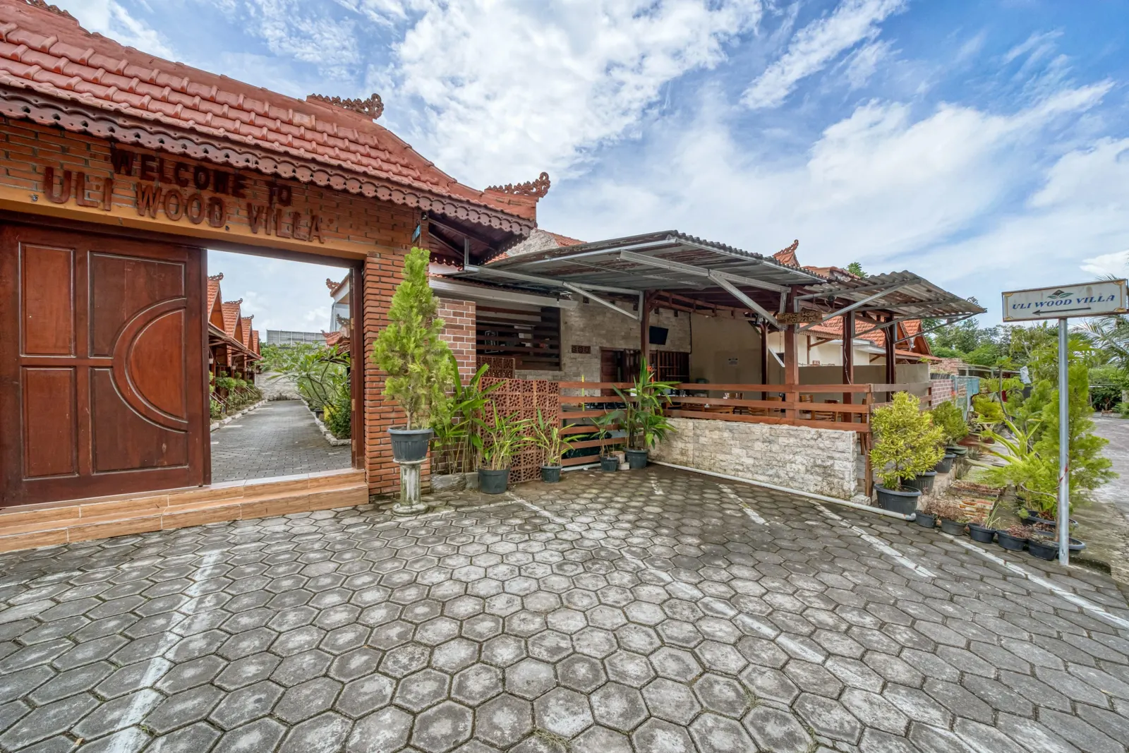 Paved courtyard with wooden villas and a shaded gazebo