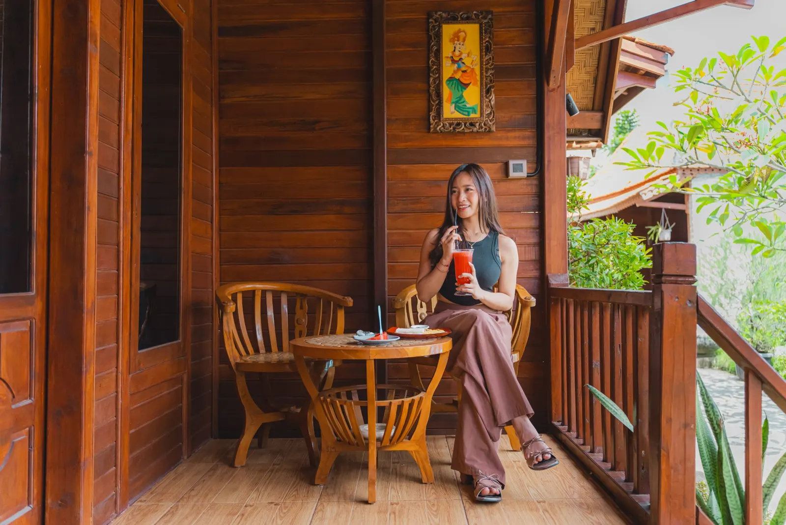 Guest seated beside a small table on a wooden veranda