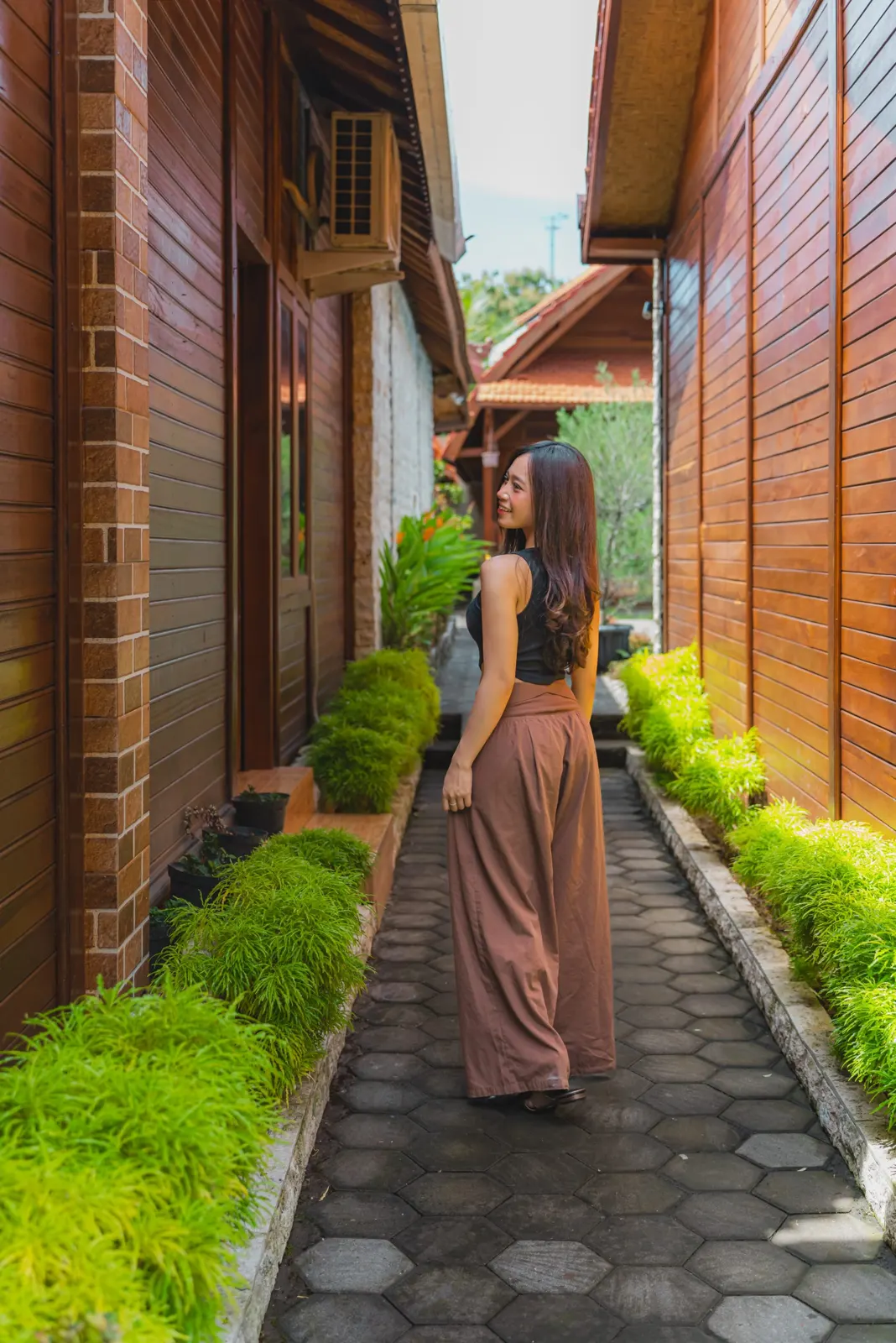 Guest walking along the narrow garden path between villas